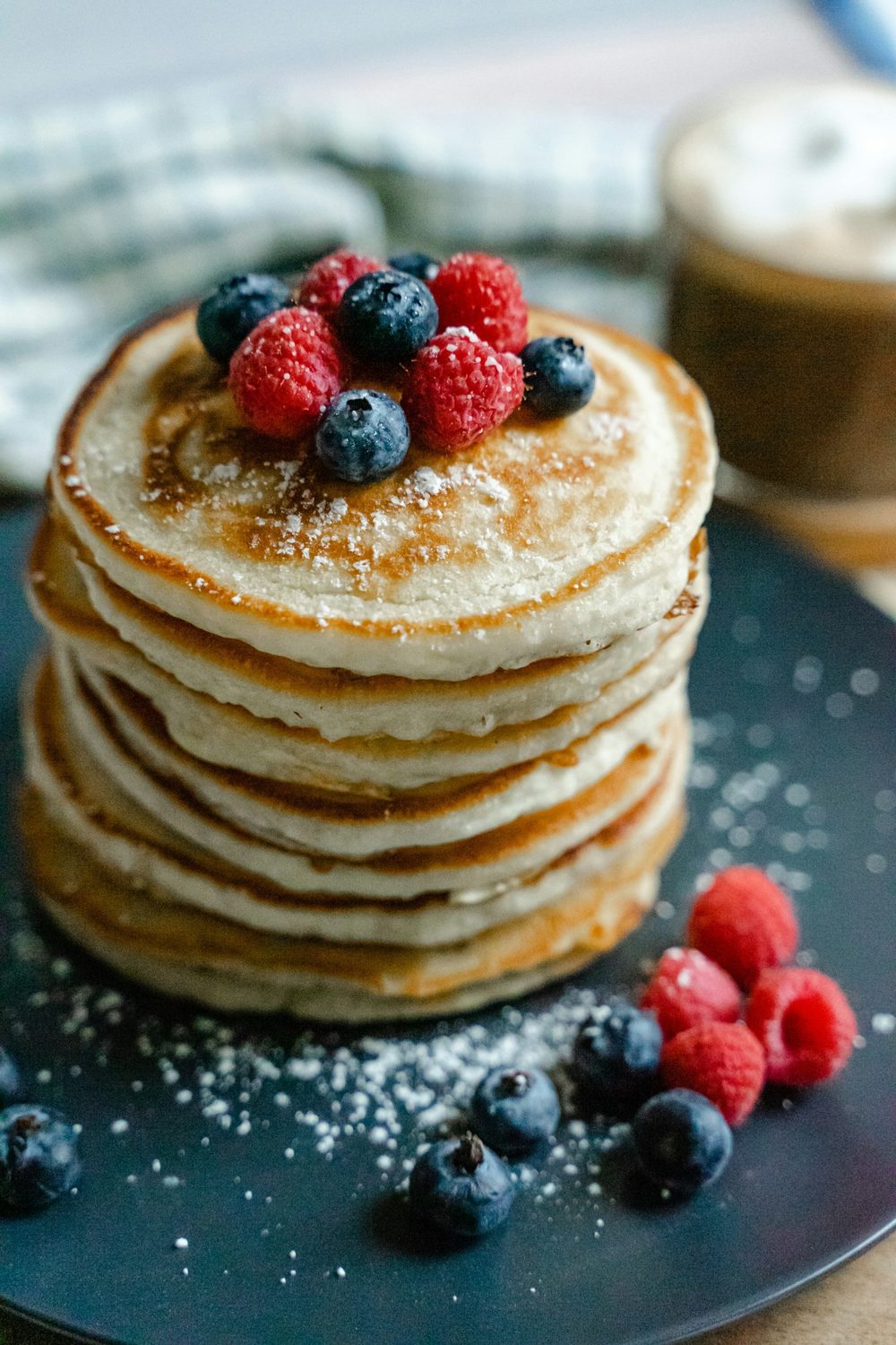 Stack of fluffy egg-free pancakes topped with berries